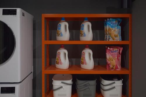 a shelf filled with milk bottles and buckets next to a microwave at Aank Hotel Seoul Sinchon in Seoul