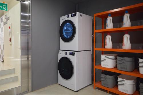a washer and dryer sitting next to a shelf at Aank Hotel Seoul Sinchon in Seoul