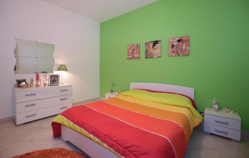 1 dormitorio con cama y pared verde en Amazing Apartment In Comiso With Swimming Pool, en Comiso
