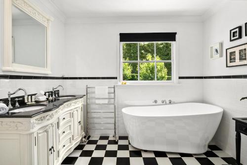 uma casa de banho branca com uma banheira e um lavatório em Lush and Charming Country Escape, Stunning Gardens em Colo Vale