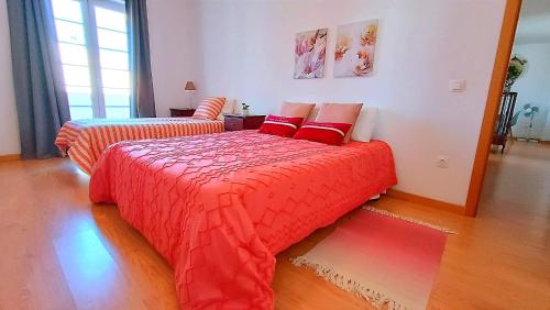 a bedroom with two beds with red comforters at Gardunha Apartments 3º Direito in Fundão
