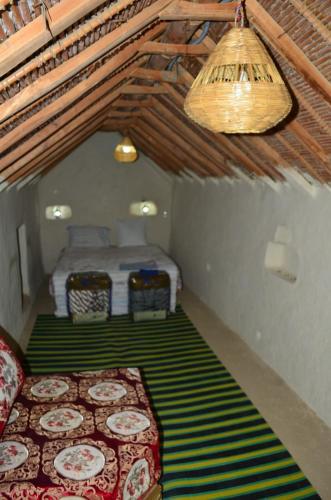 a bedroom with two beds in a room with a bed at AUBERGE El HAJ BOUAYYADY ZOUAKINE in Guezira