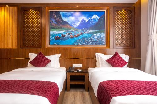 two beds in a room with a painting on the wall at Kailash Boutique Hotel in Kathmandu