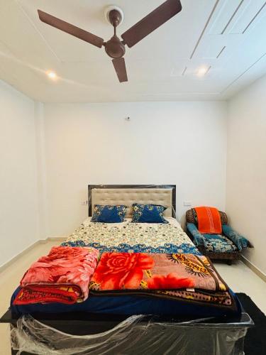 a bed in a room with a ceiling fan at Atithi Dev Guest House in Ayodhya