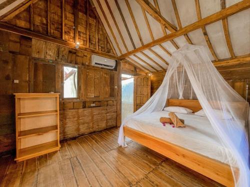 a bedroom with a bed with a mosquito net at Mimpi Bungalow in Gili Meno