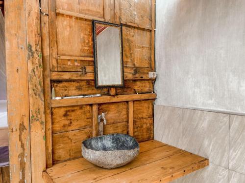 a bathroom with a stone sink and a mirror at Mimpi Bungalow in Gili Meno