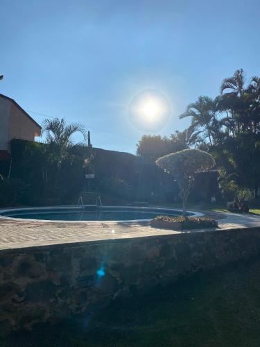 una piscina con un árbol en un patio en Quinta Ángeles en Cuernavaca