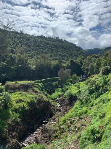 een uitzicht op een heuvel met een rivier in een veld bij Hacienda la campiña in Quito