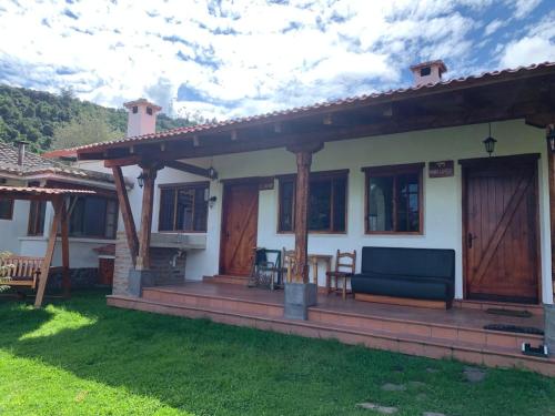 een huis met een veranda met een blauwe bank bij Hacienda la campiña in Quito