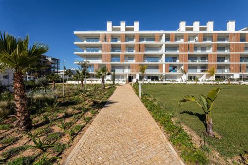 ein großes Gebäude mit einem Weg davor in der Unterkunft The Albufeira Concierge - Prime Sunset Design in Albufeira