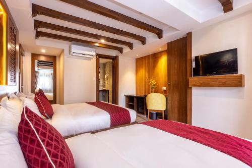 a hotel room with two beds and a television at Kailash Boutique Hotel in Kathmandu