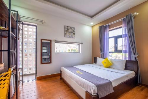 a bedroom with a bed and two windows at Richy Dalat Hotel in Da Lat