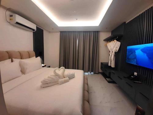 a bedroom with a large white bed and a flat screen tv at The Clover Hotel in Angeles