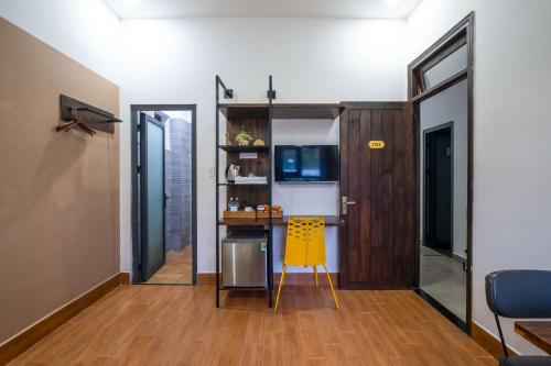 a small kitchen with a yellow chair in a room at Richy Dalat Hotel in Da Lat