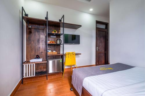 a bedroom with a bed and a yellow chair at Richy Dalat Hotel in Da Lat
