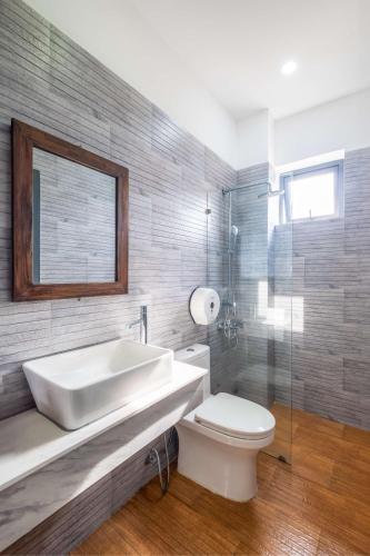 a bathroom with a tub and a toilet and a sink at Richy Dalat Hotel in Da Lat