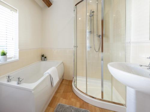 a bathroom with a bath tub and a sink at 5 Bed in York 77267 in Green Hammerton