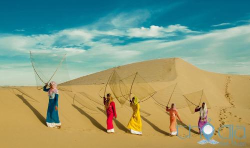 a group of women standing in the desert with nets at Căn hộ Hacom in Phan Rang