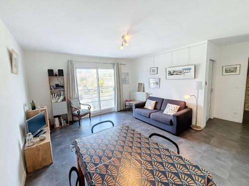 un salon avec un canapé et une table dans l'établissement Appartement moderne centre-ville, 600m plage, résidence sécurisée, parking - FR-1-361-368, à Granville