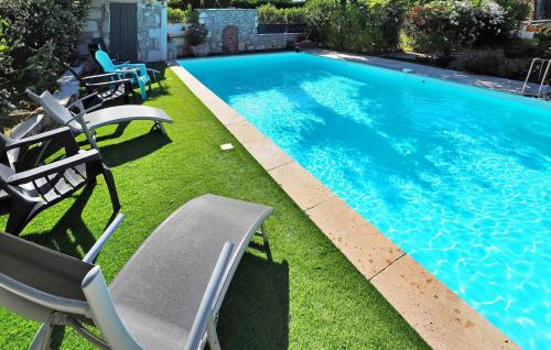 a swimming pool with lawn chairs and a swimming pool at Zèbre in Eyragues