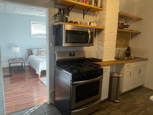 a kitchen with a stove and a microwave at The Columbus Hideaway Den in Columbus