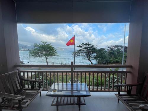 a view of the ocean from a balcony with a flag at Hotels Trạm Kiểm Lâm Cơ Động - Con Dao National Park in Con Dao