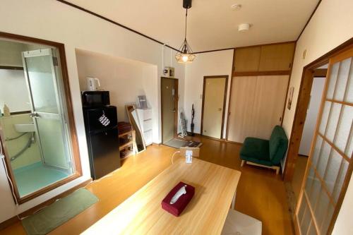 sala de estar con mesa de madera y silla verde en On JR Line, Direct to Ikebukuro, Shinjuku/Shibuya 01, en Tokio