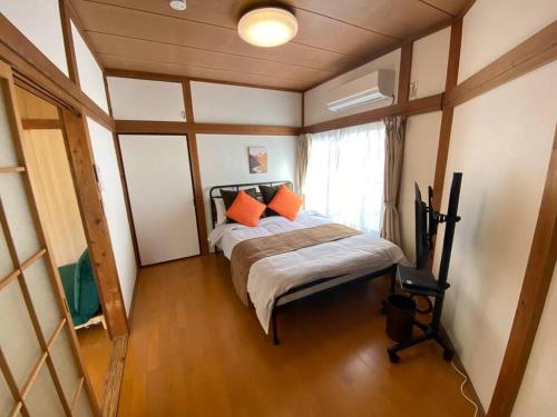 1 dormitorio con 1 cama con almohadas de color naranja en On JR Line, Direct to Ikebukuro, Shinjuku/Shibuya 01, en Tokio