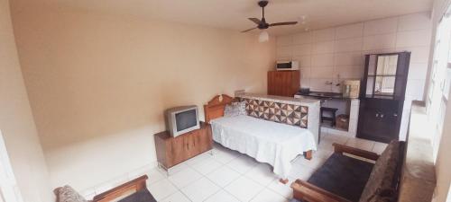 a room with a bed and a tv in it at Edicula Paz e Amor in Piracicaba