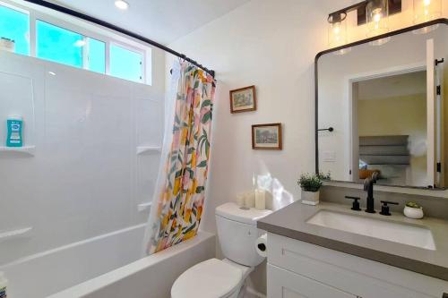 a bathroom with a toilet and a sink and a mirror at Entire Modern 3-Bedroom Home with Balcony Views near San Diego Gaslamp, 10 Guests Maximum in National City