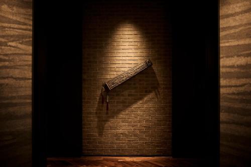 a knife on a brick wall with a shadow at The Royal Park Hotel Iconic Nagoya in Nagoya