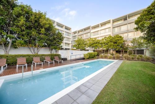 a swimming pool in front of a building at Oaks Nelson Bay Lure Suites in Nelson Bay