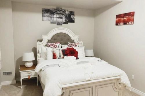 een slaapkamer met een groot wit bed met rode kussens bij Luxury Room in Mississauga