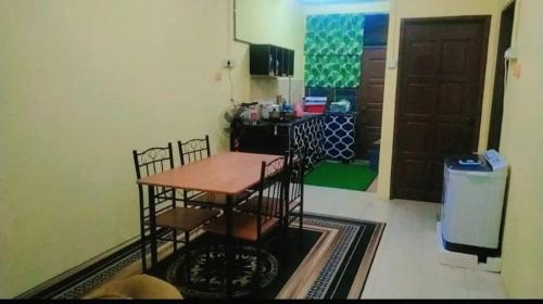 a kitchen with a table and chairs in a room at Pengkalan Sayangku Homestay islam in Masjid Tanah
