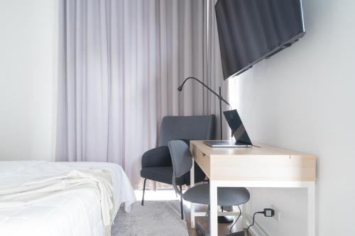 a bedroom with a desk with a computer and a bed at Modern 4 Bedroom House I Close to Malls I Swimming Pool I Maximum 12 Guests I by Bleuspace in Tagum