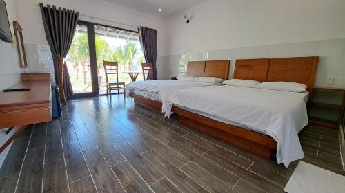 1 dormitorio con 1 cama grande y suelo de madera en Konklor Hotel, en Kon Tum (2)