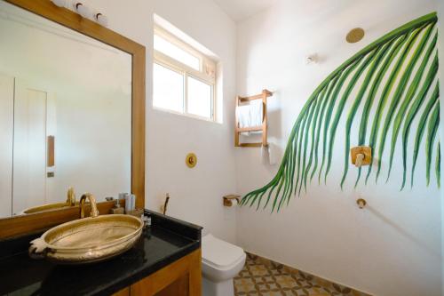 a bathroom with a sink and a toilet with a painting on the wall at Nilaya Stays in Padubidri