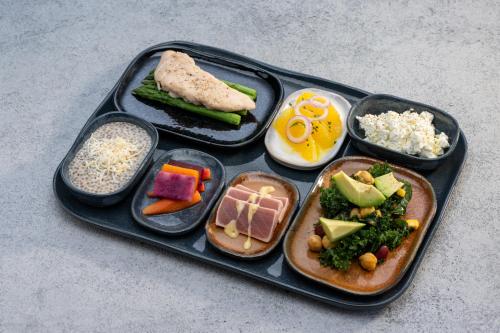 a black tray with different types of food on it at CHAO Sanlitun Beijing in Beijing