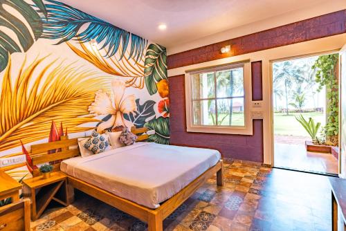 een slaapkamer met een groot bed en een muurschildering bij Nilaya Stays in Padubidri
