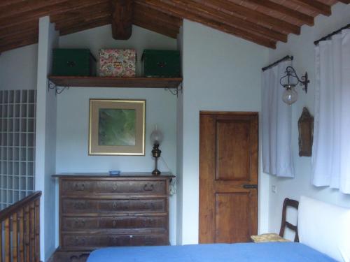 1 dormitorio con cama y tocador de madera en La Vigna Apartment, en Siena