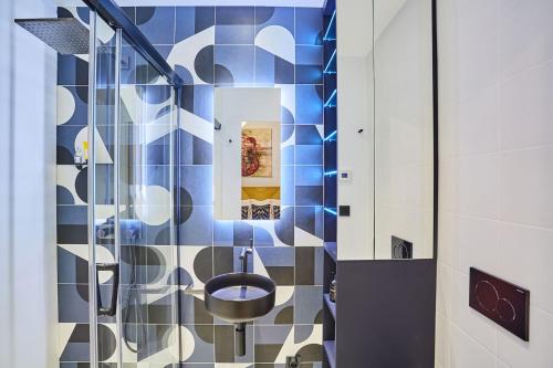 a bathroom with blue and white tiles and a toilet at Designer luxury flat in Central Paris - 2bed 2bath with AC in Paris