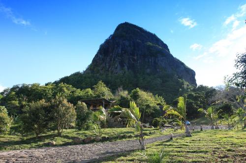 a mountain with a house in front of it at La Hacienda Mauritius in Mahébourg