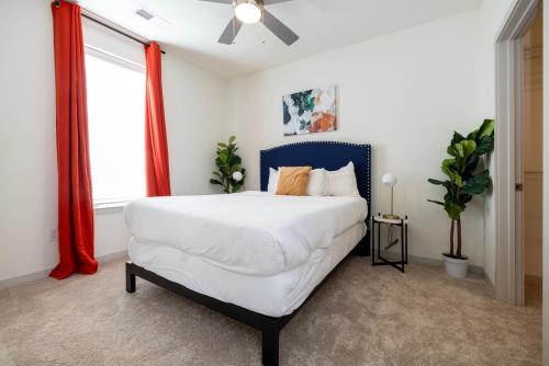 a bedroom with a large white bed and a window at Modern Nulu 2BR CozySuites 05 in Louisville