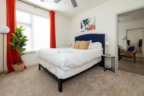 Modern Nulu 2BR CozySuites 05 في لويزفيل: غرفة نوم مع سرير كبير مع اللوح الأمامي الأزرق