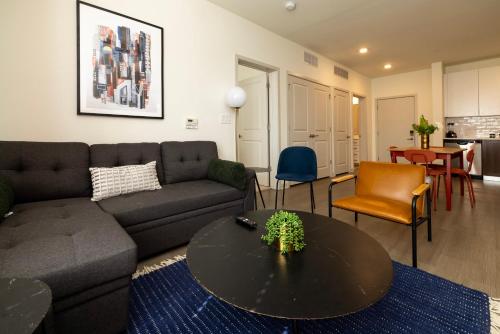 a living room with a couch and a table at Modern Nulu 2BR CozySuites 05 in Louisville