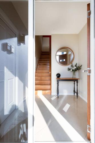 a hallway with a mirror and a table at Riverview Escape in Inveresk