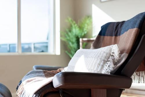 a chair with a blanket and a pillow on it at Riverview Escape in Inveresk