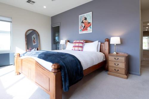 a bedroom with a wooden bed with a blue wall at Riverview Escape in Inveresk