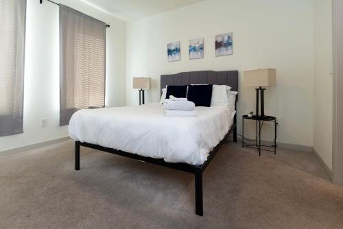 a bedroom with a large white bed with two lamps at Stunning Nulu 1BR CozySuites 05 in Louisville