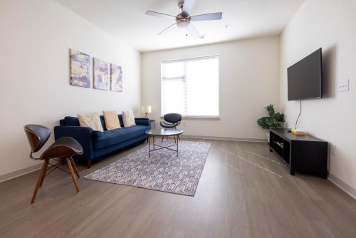 a living room with a blue couch and a tv at Stunning Nulu 1BR CozySuites 05 in Louisville